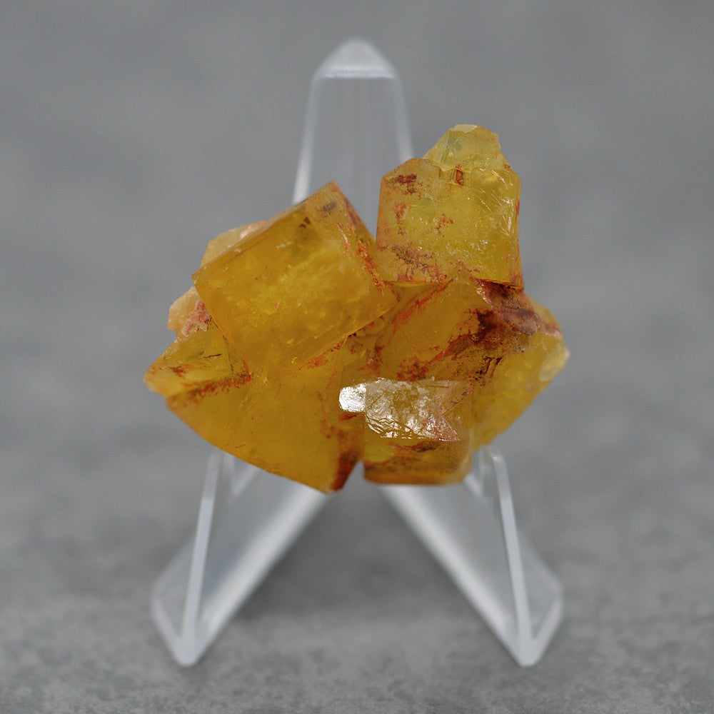 Amas de fluorite maclée jaune orange de 31g sur présentoir