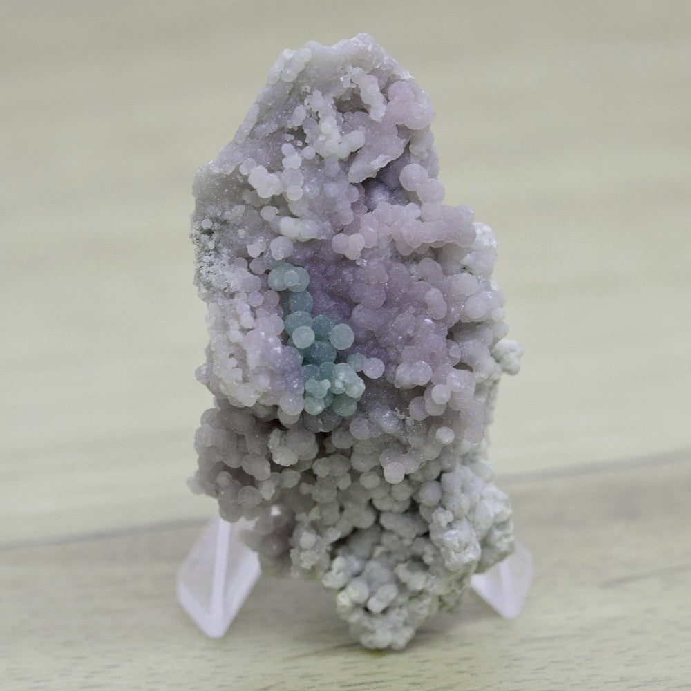 Calcédoine botryoïde violette à tâches vertes et jaunies sur présentoir 52g