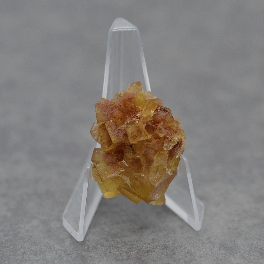 Petite fluorite jaune miel foncée de 20g sur présentoir